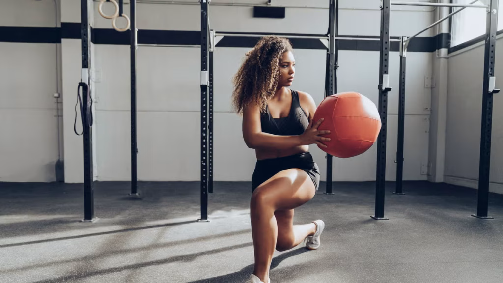 young-woman-exercising-with-medicine-ball-in-gym-royalty-free-image-1636651052